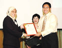 Riza Partoredjo receiving her award from Dr Maliki Osman.